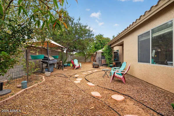 a backyard of a house with barbeque oven and outdoor seating