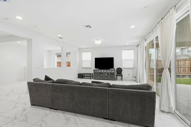 a kitchen with stainless steel appliances kitchen island granite countertop a table chairs and a refrigerator