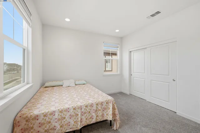 a spacious bedroom with a bed and a cabinets