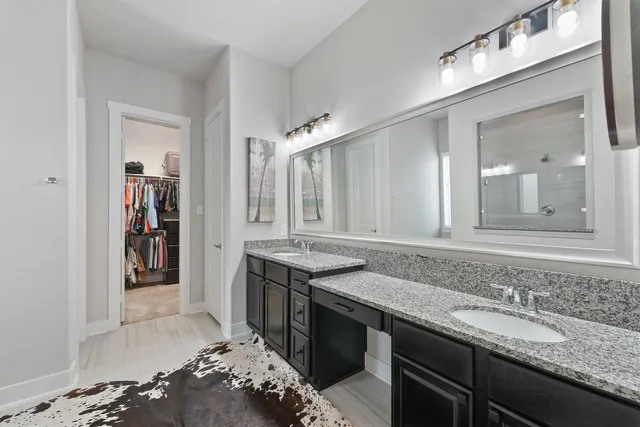 a bathroom with a granite countertop sink a mirror and shower