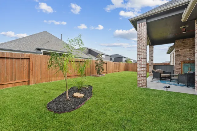 a backyard of a house with barbeque oven and outdoor seating
