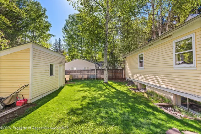 a backyard of a house with table and chairs