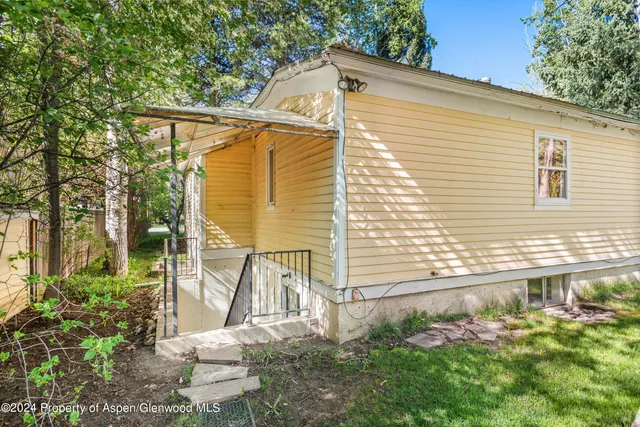 a view of a house with backyard and sitting area