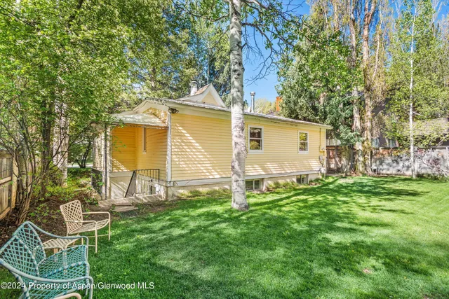 a backyard of a house with table and chairs