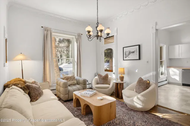 a living room with furniture chandelier and a window