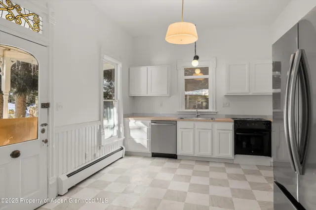 a kitchen with a refrigerator and a stove top oven