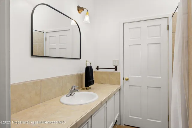 a bathroom with a granite countertop sink and a mirror