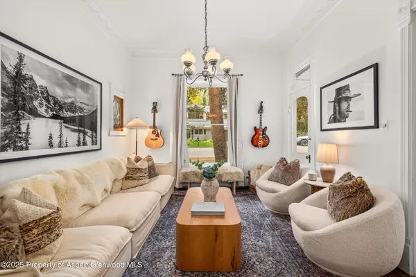 a living room with furniture a chandelier and a window