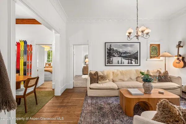 a living room with furniture chandelier and a large window