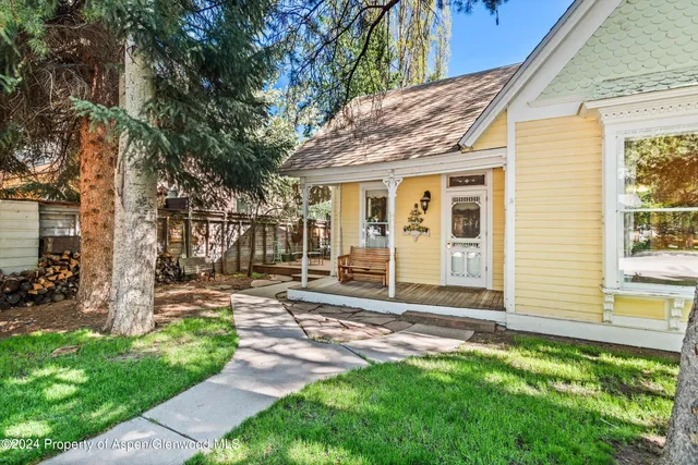 a backyard of a house with a garden and barbeque oven