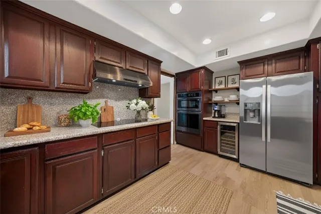 a kitchen with granite countertop stainless steel appliances and wooden cabinets