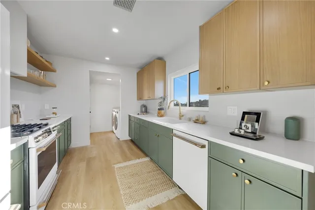 a kitchen with stainless steel appliances granite countertop a refrigerator a sink and a stove