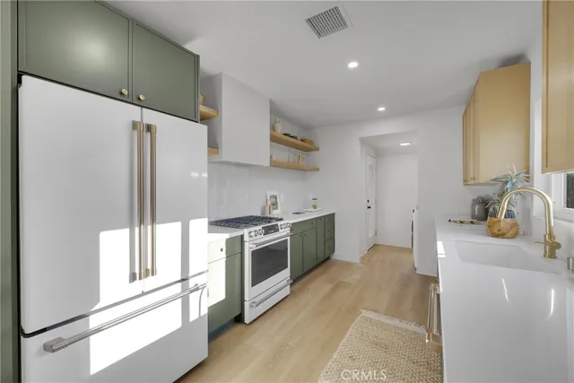 a kitchen with stainless steel appliances a sink stove and refrigerator