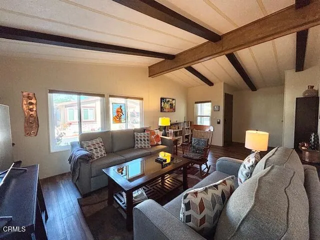 a living room with furniture a wooden floor and a flat screen tv