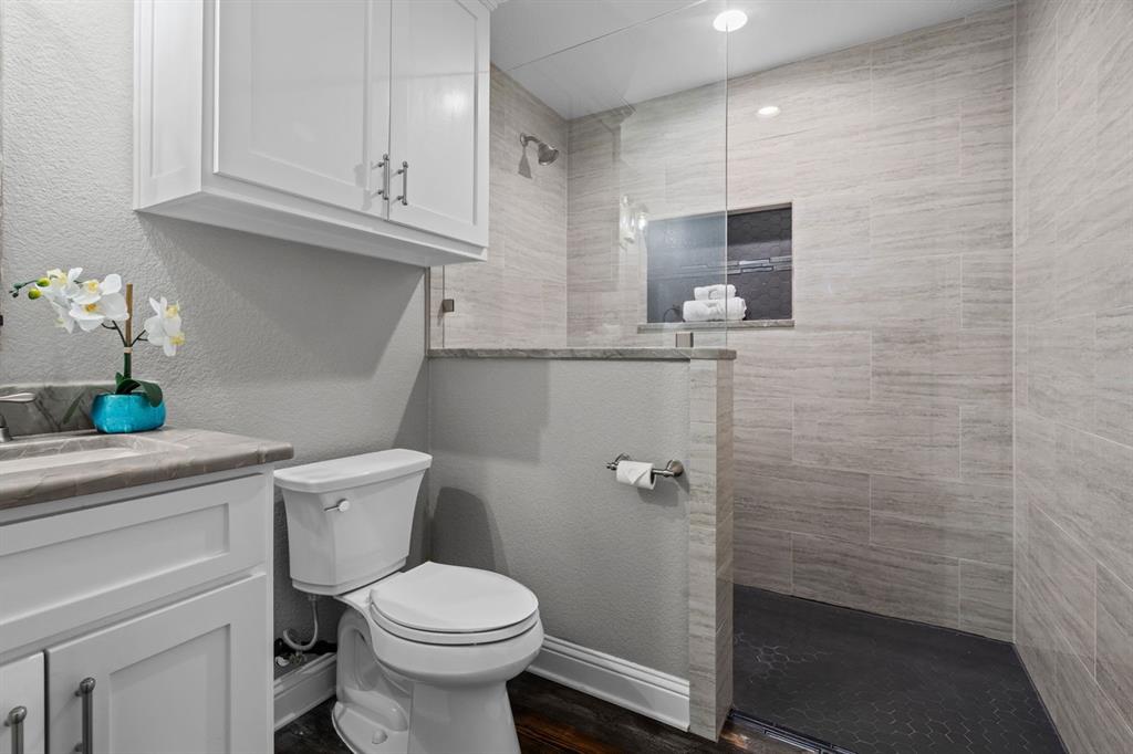 175 Porter Road Bartonville, TX 76226 - Photo 33 of 40 a bathroom with a toilet a sink and glass door