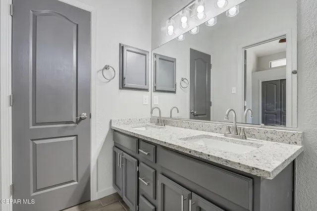 a bathroom with a granite countertop sink and a mirror