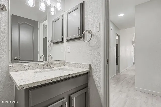 a bathroom with a granite countertop sink a mirror and a shower