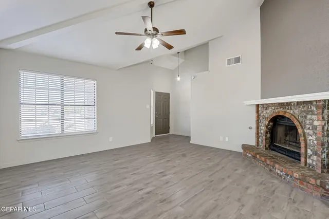 wooden floor fireplace and windows in an empty room