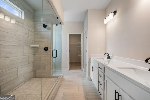 a bathroom with a double vanity sink a toilet and shower