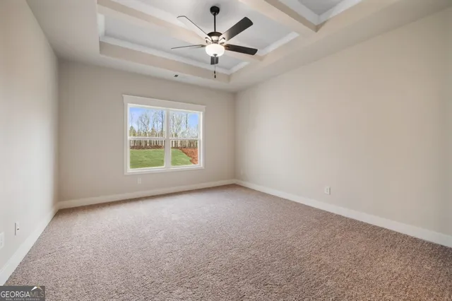 an empty room with windows and fan