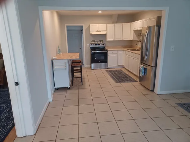 a kitchen with stainless steel appliances granite countertop a refrigerator and a stove top oven