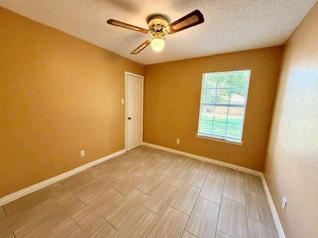 2604 Crix Lane Fort Worth, TX 76140 - Photo 8 of 13 Spacious room featuring neutral wall tones, large window, ceiling fan with integrated lighting, and light-toned tile flooring
