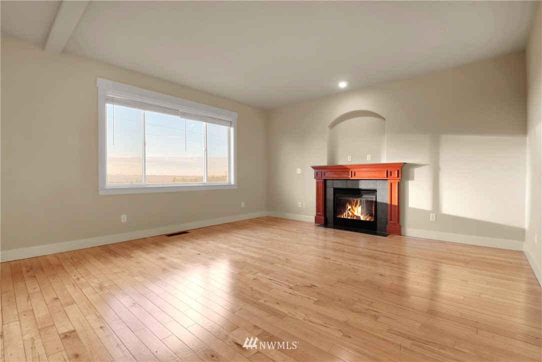 22632 43rd Drive Southeast Bothell, WA 98021 - Photo 23 of 33 an empty room with wooden floor fireplace and windows
