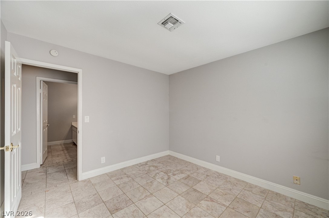 6635 Costa Brava Road Las Vegas, NV 89146 - Photo 38 of 59 A well-maintained bedroom offers durable tile flooring, ready for personalization.