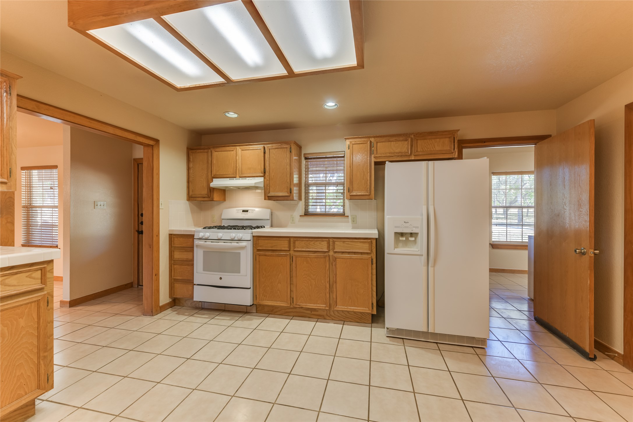 1201 Sandy Point Road Wimberley, TX 78676 - Photo 17 of 40 a kitchen with a refrigerator a sink and a stove top oven