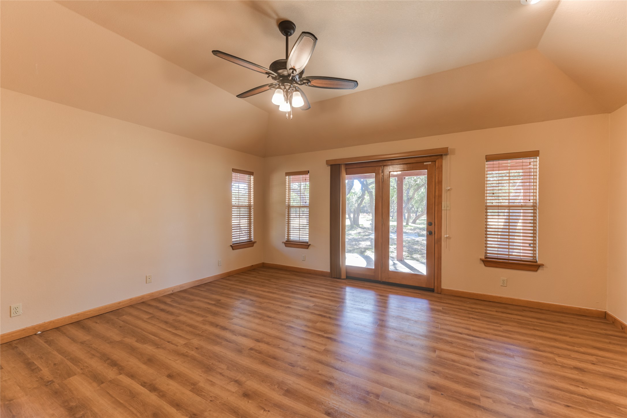 1201 Sandy Point Road Wimberley, TX 78676 - Photo 19 of 40 a view of an empty room with wooden floor and a window