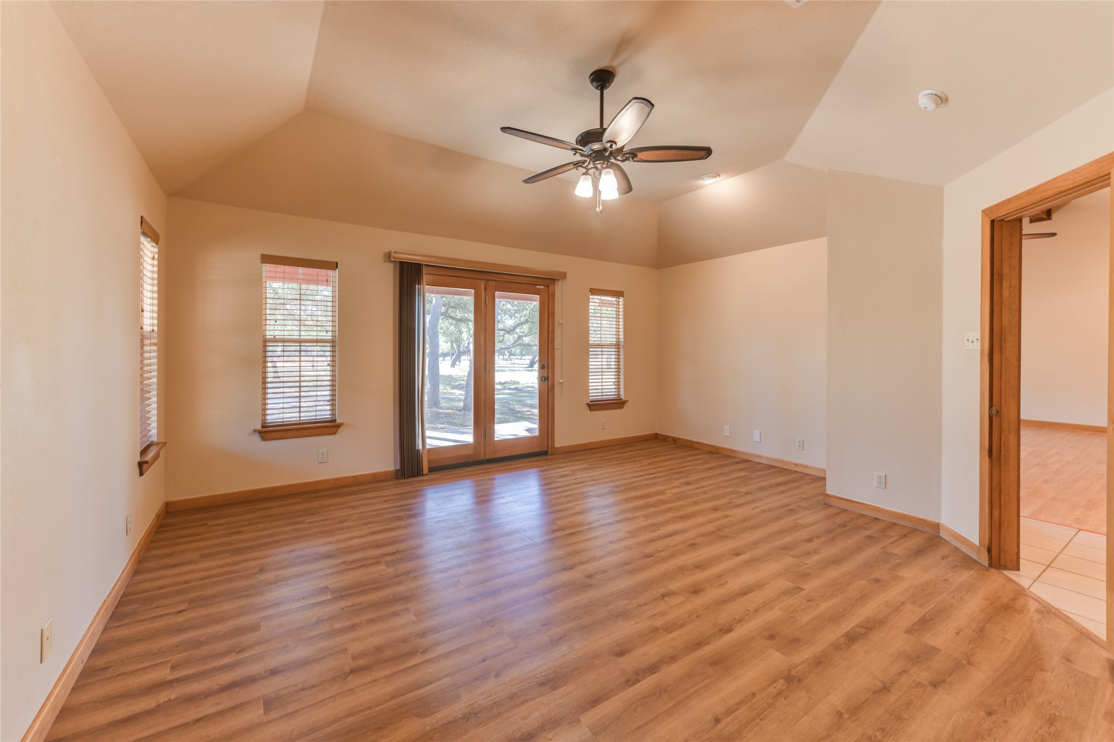 1201 Sandy Point Road Wimberley, TX 78676 - Photo 20 of 40 a view of an empty room with window and wooden floor