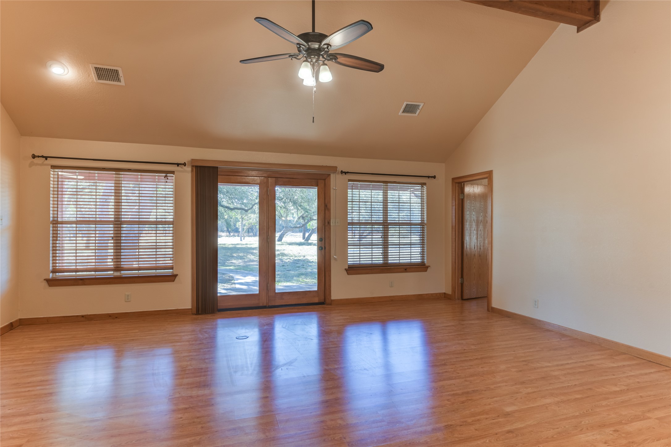 1201 Sandy Point Road Wimberley, TX 78676 - Photo 10 of 40 a view of an empty room with a window and wooden floor