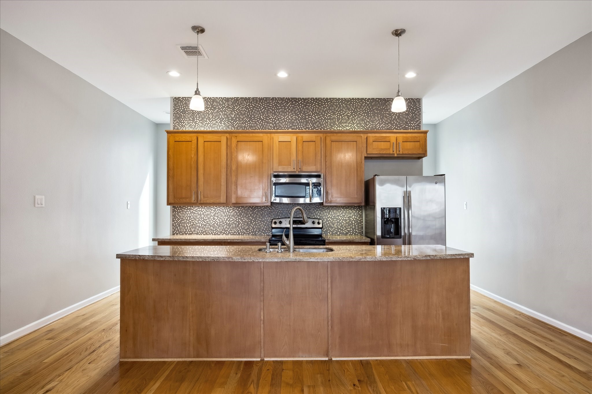 802 Waverly Street, Unit D Houston, TX 77007 - Photo 7 of 30 a kitchen with kitchen island stainless steel appliances a sink and a window
