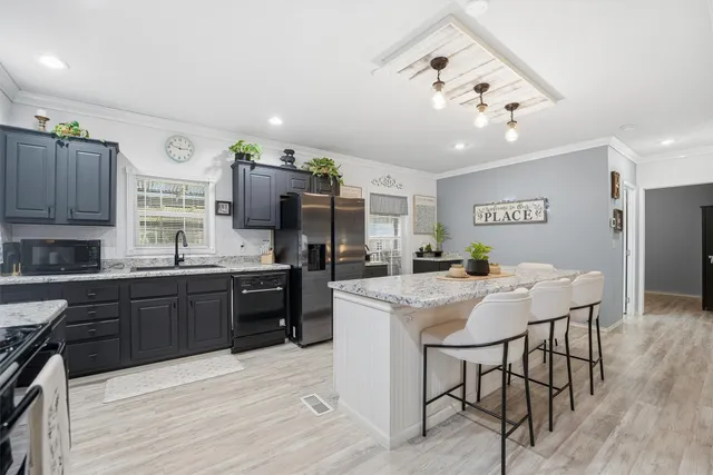 a kitchen with stainless steel appliances kitchen island granite countertop a sink and cabinets