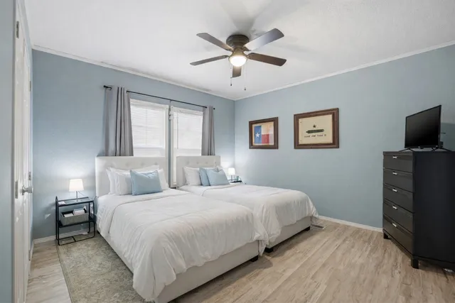 a bedroom with a bed and a flat tv screen on dresser