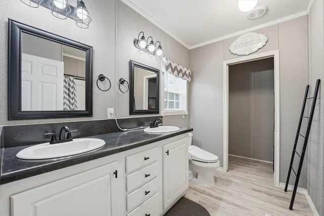 a bathroom with a granite countertop sink a toilet a mirror and shower
