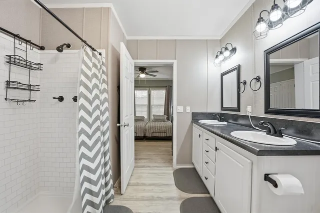 a en suite bathroom with a double vanity sink mirror and shower