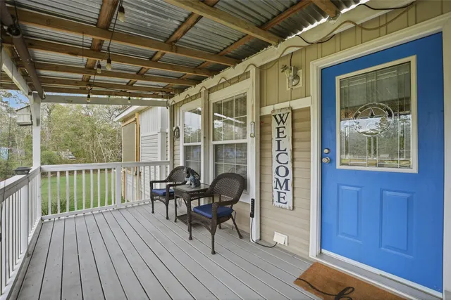 a view of a porch with wooden floor and furniture