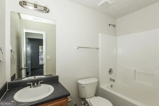 a bathroom with a sink toilet a mirror and shower