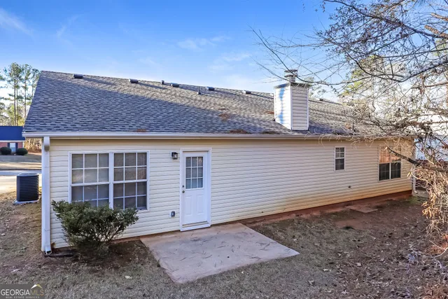a view of a house with a yard and potted plants