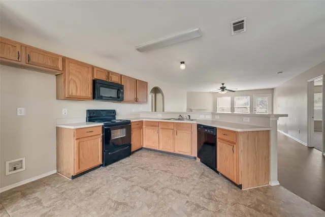 a large kitchen with stainless steel appliances granite countertop a stove refrigerator sink and cabinets