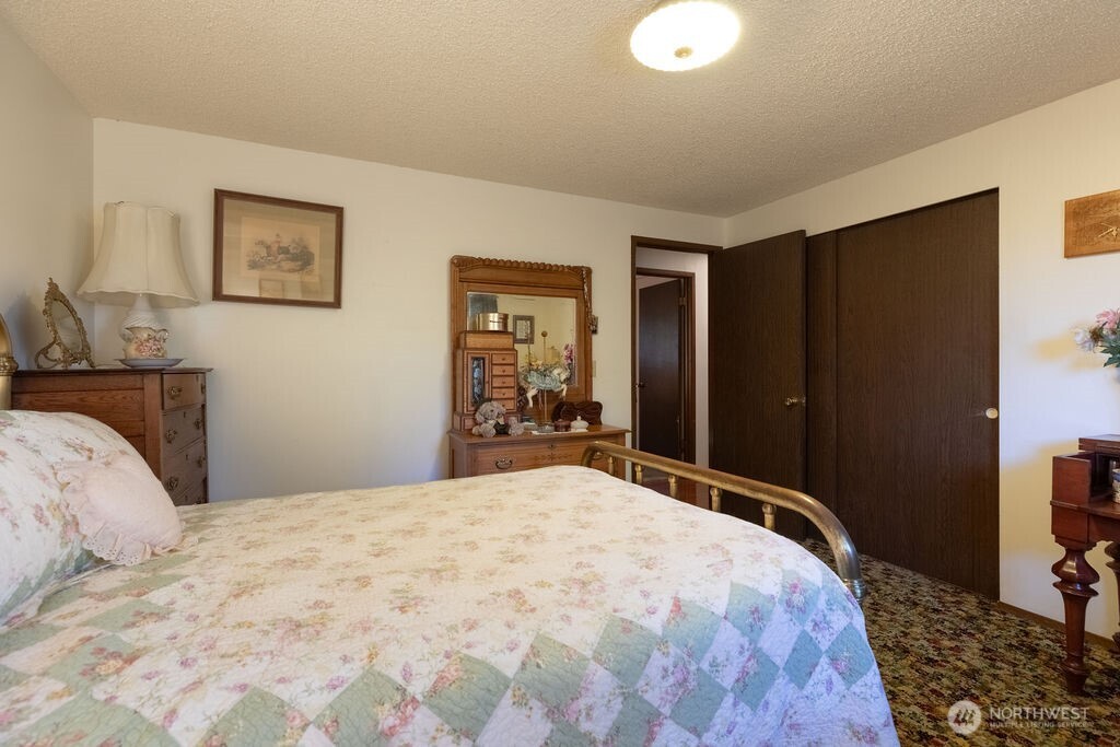 371 Flora Place Forks, WA 98331 - Photo 17 of 40 a bedroom with a large bed and a dresser