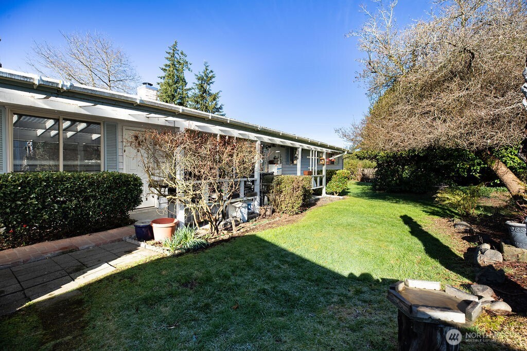 371 Flora Place Forks, WA 98331 - Photo 27 of 40 a view of a patio with table and chairs potted plants and large tree
