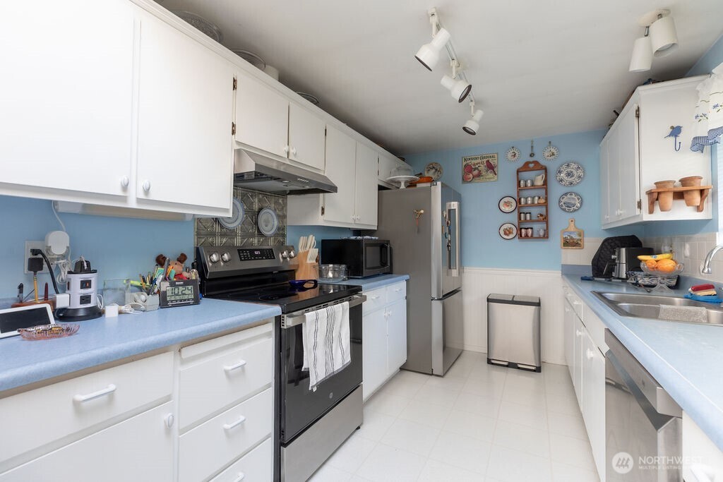 371 Flora Place Forks, WA 98331 - Photo 7 of 40 a kitchen with stainless steel appliances granite countertop a sink dishwasher stove and refrigerator with cabinets