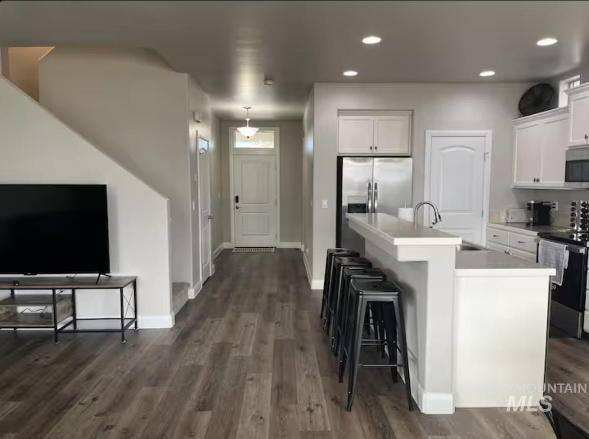 723 Stallion Springs Way Middleton, ID 83644 - Photo 2 of 50 Kitchen with white cabinets, stainless steel appliances, light countertops, a kitchen bar, and recessed lighting