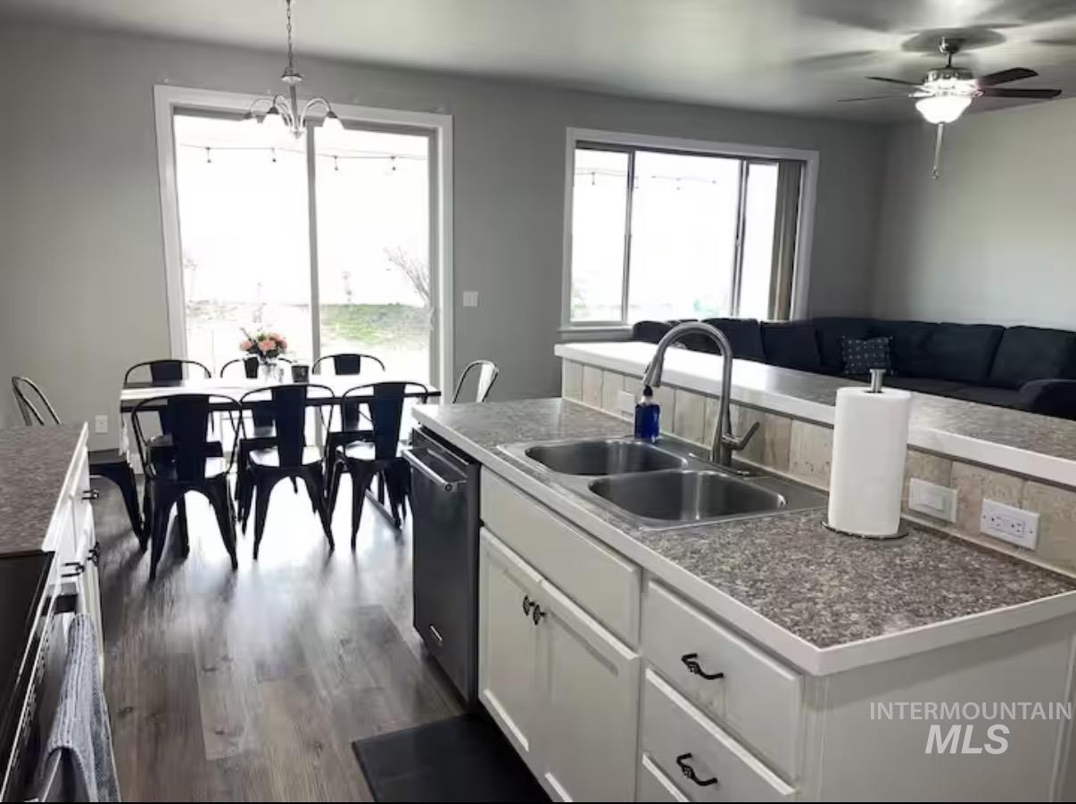 723 Stallion Springs Way Middleton, ID 83644 - Photo 50 of 50 Kitchen featuring white cabinets, pendant lighting, dark wood-style flooring, dishwashing machine, and open floor plan
