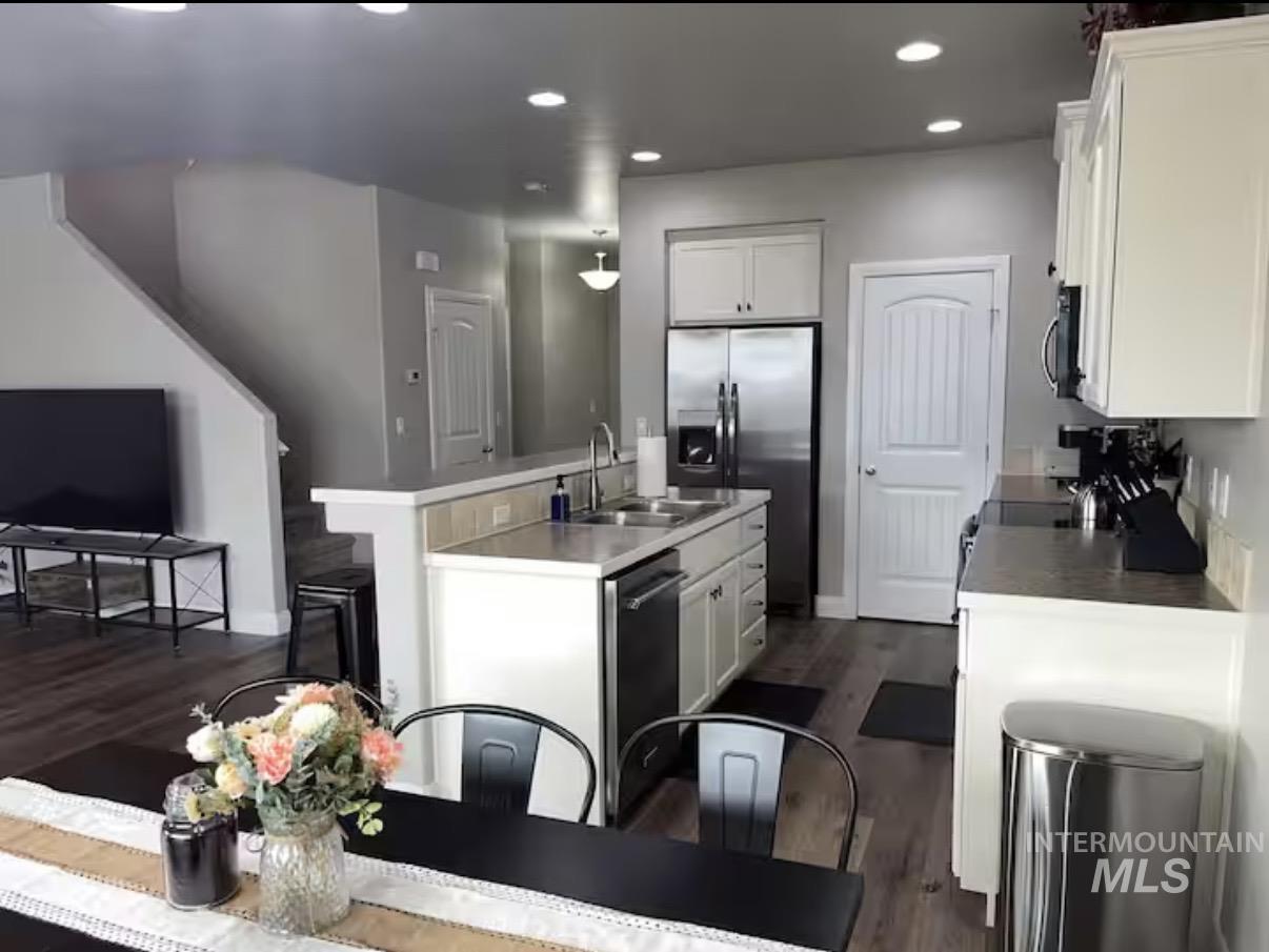 723 Stallion Springs Way Middleton, ID 83644 - Photo 3 of 50 Kitchen with white cabinetry, stainless steel appliances, recessed lighting, dark wood-type flooring, and light countertops