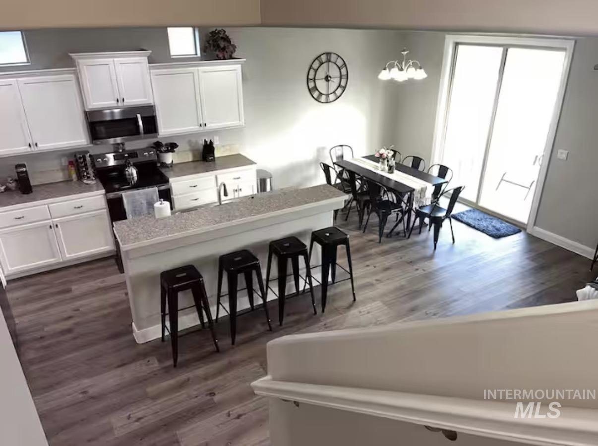 723 Stallion Springs Way Middleton, ID 83644 - Photo 5 of 50 Kitchen with white cabinetry, a breakfast bar, stainless steel appliances, and plenty of natural light