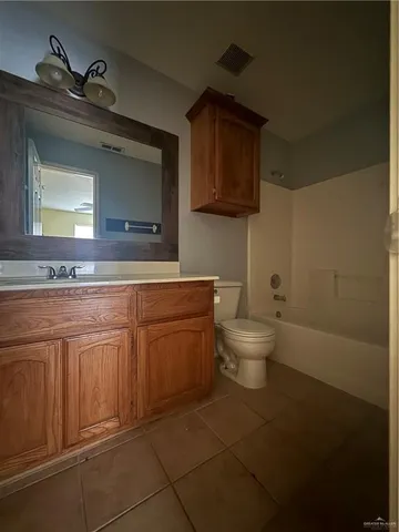 a bathroom with a granite countertop toilet sink and mirror