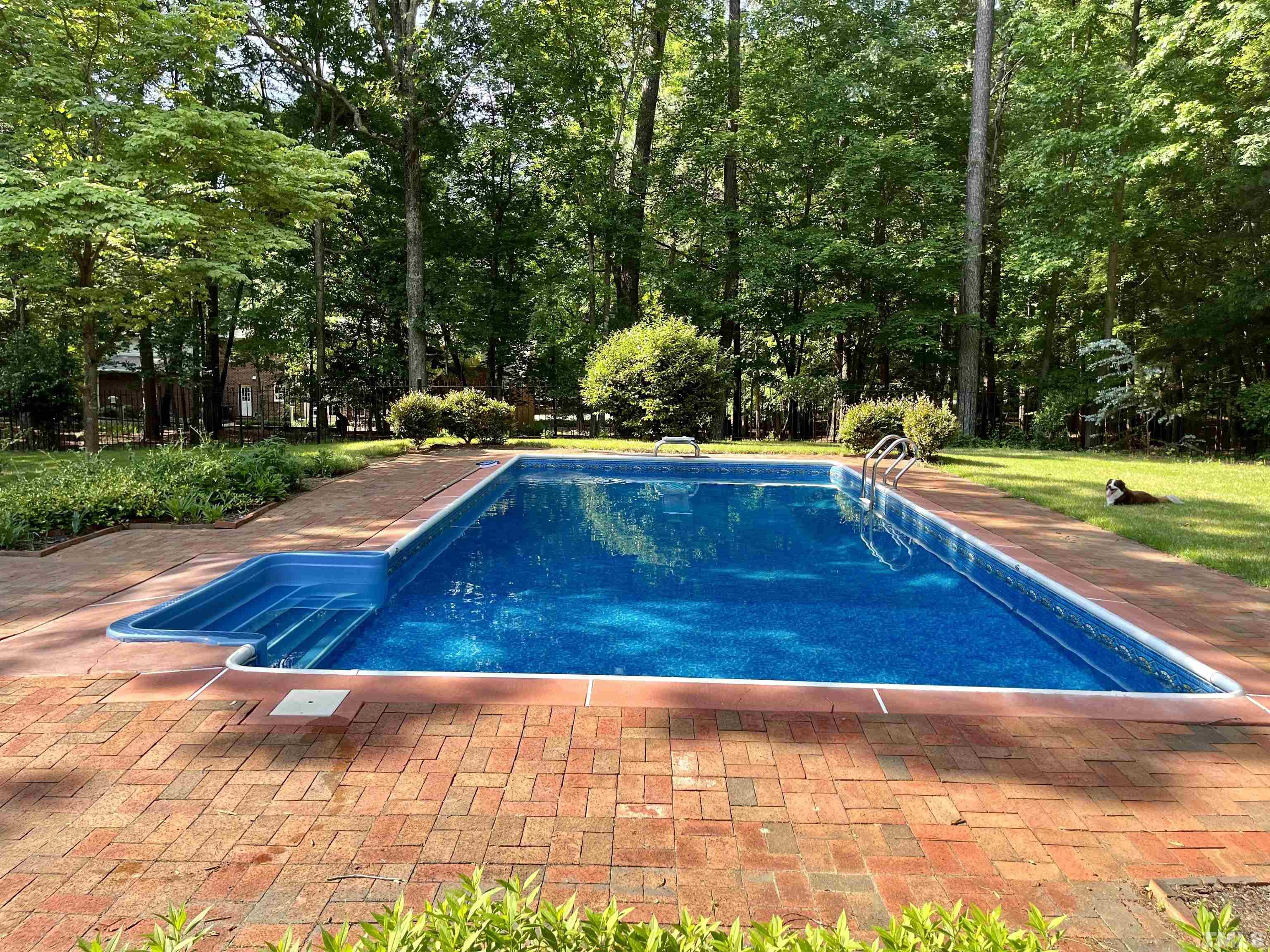 212 Carpathian Way Raleigh, NC 27615 - Photo 4 of 24 a view of a swimming pool with an outdoor space and seating area